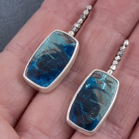 Azurite earrings in brushed sterling silver with embellished ear wires, held in hand to show scale