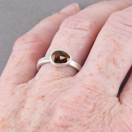 Brown tourmaline ring in brushed sterling silver worn on hand to show size