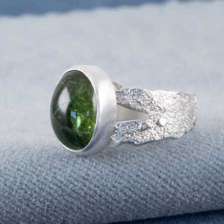 Sideview of green tourmaline ring in bright textured sterling silver