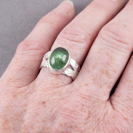 Green tourmaline ring worn on hand to show scale
