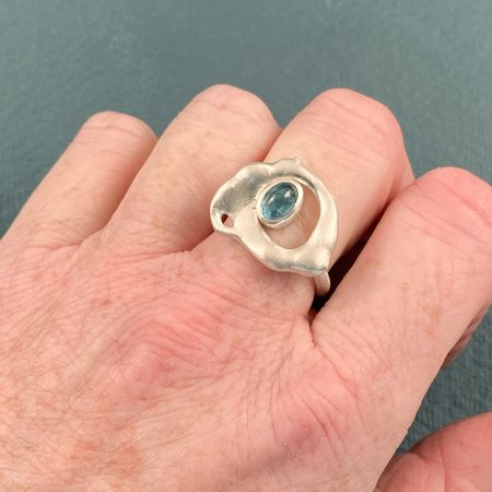 Aquamarine and fused sterling silver ring in brushed finish shown on a hand for scale